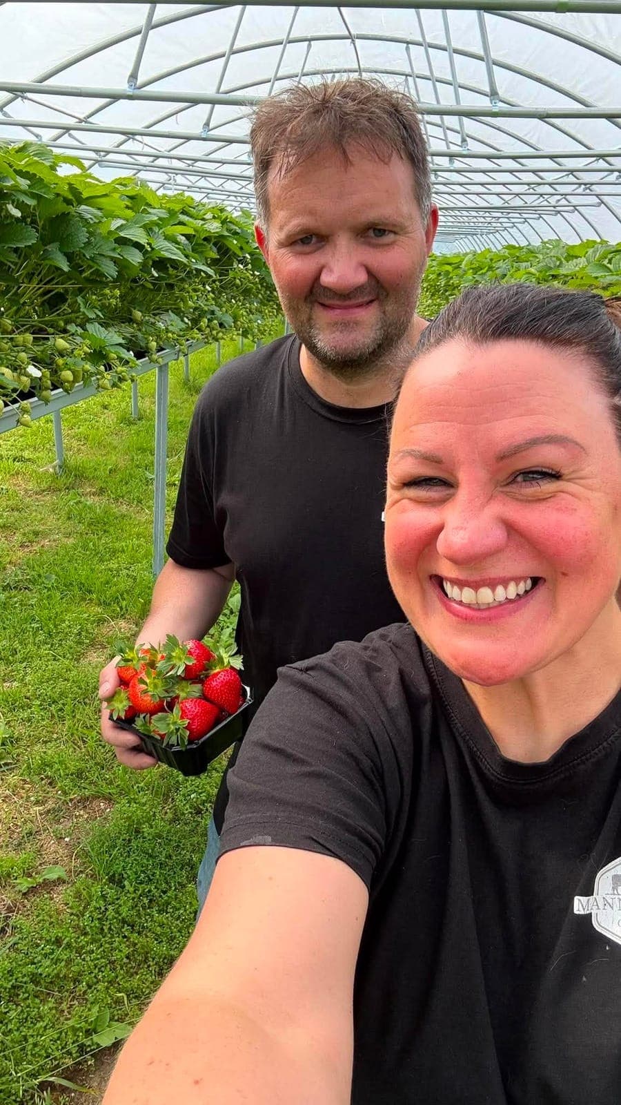 Ove und Cecilie Mannsverk mit frisch gepflückten Erdbeeren im Anbautunnel